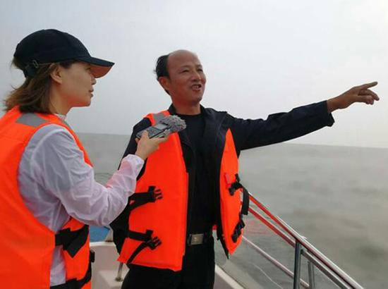 记者在洪湖上采访。