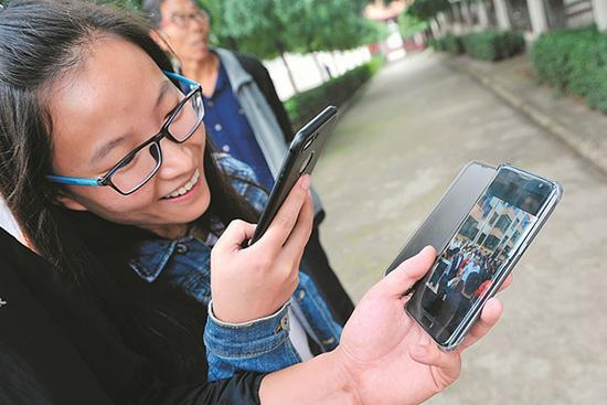 在石圪节中兴小区，居民拿着手机相互传阅拍到的总理前来视察的视频。