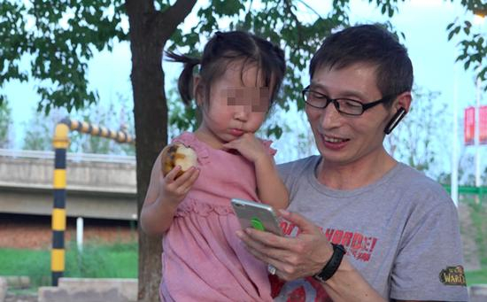 司机师傅胡爱松陪依依玩，给她放手机里的动画片。&nbsp; 澎湃新闻记者 朱莹 图