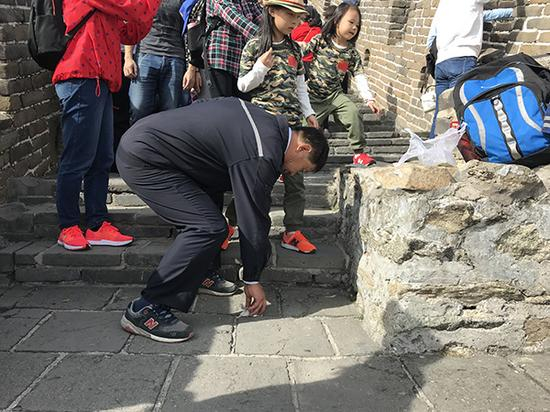 王茂海随时弯腰捡地上的垃圾。