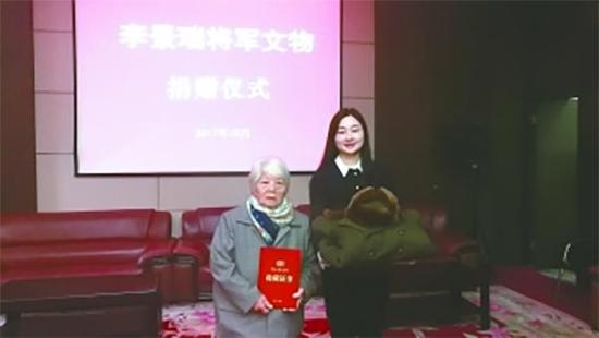 李景瑞夫人徐义宁（左）向新四军纪念馆捐赠将军穿戴过大衣和冬帽。盐城晚报 图