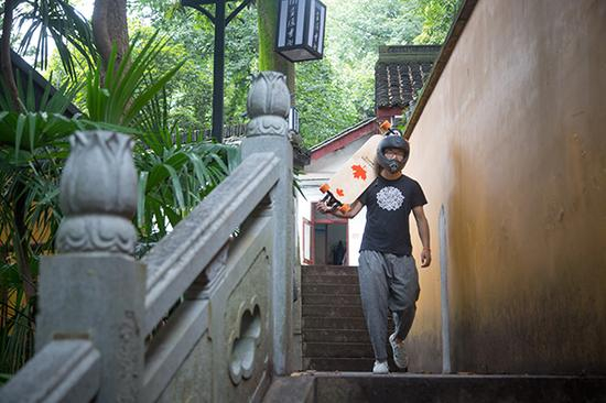 赵莲贵拿着喜爱的滑板走下山。 本文图片来源： 受访者供图、东方IC