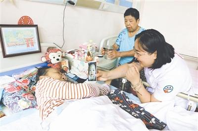 董伟给张贞娥看自己孩子的照片 。