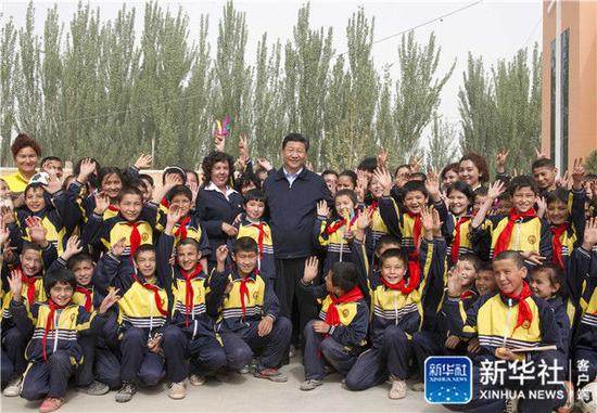 2014年4月28日，习近平在新疆疏附县托克扎克镇中心小学同师生们合影。新华社记者 谢环驰 摄