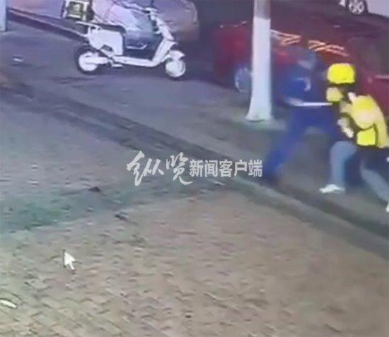 视频中身穿蓝色衣服男子持刀捅向外卖员。(来源/视频截图)