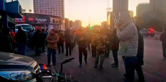 　　清晨，在距离女子宿舍不到500米的零工集散地湖北市场，很多人站在街头等活儿。摄影/本刊记者 隗延章