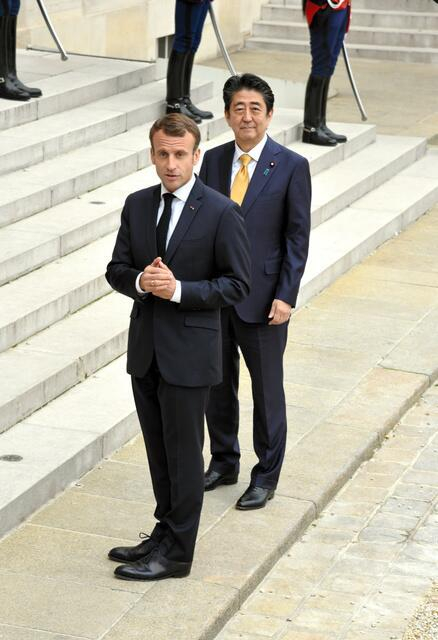 被希比尔·维隆喊住回头的马克龙与安倍（图片来源：日本《朝日新闻》）