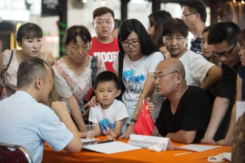 　　2017年11月30日，在印度尼西亚巴厘岛火山喷发后导致机场关闭，图为中国游客在机场向中国驻登巴萨总领馆工作人员咨询情况。（新华社）