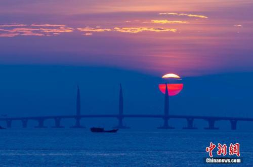　　10月22日早晨，从广东珠海市的情侣路向东眺望，一轮红日从东方冉冉升起，将港珠澳大桥映射得格外迷人。“超级工程”港珠澳大桥将于24日上午9时正式通车。中新社记者 张炜 摄