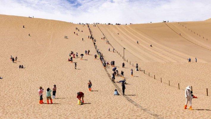 甘肃敦煌：游客爬鸣沙山 观月牙泉