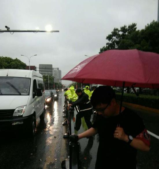 城管中队和交警合力扶起中间隔离带。&nbsp;嘉定区供图