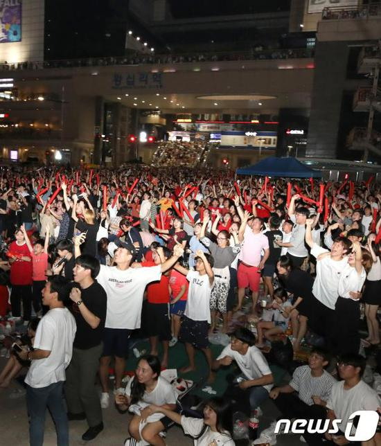 首尔城东区的往十里广场涌入了大量韩国球迷，他们见证了孙兴慜摘金的历史性一刻。