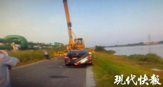 民警联系大型吊车将落水轿车吊起