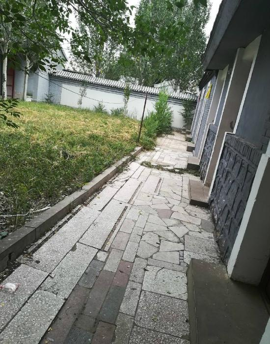 曾去沽源塞外庄园景区的游客称，景区入住房间外草坪长满杂草。受访者供图