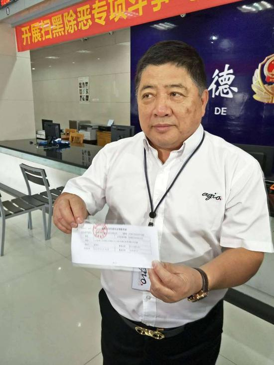 全国台企联会长王屏生手持居住证办理回执联。（图片来源：台媒）
