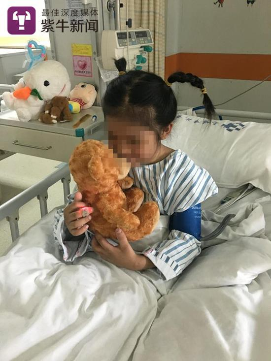 洁洁躺在病床上，抱着喜爱的玩偶