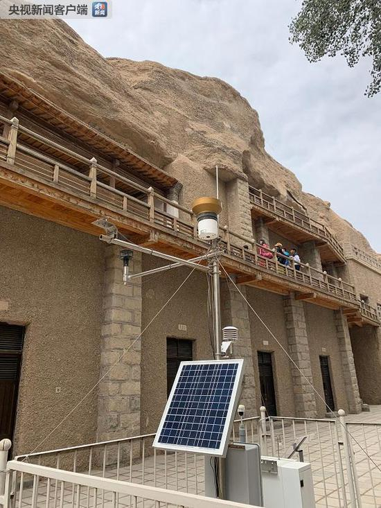 　　△为保障洞窟壁画和彩塑保存环境稳定，敦煌研究院采用现代物联网技术构建了莫高窟监测预警体系。这是处于莫高窟第72窟前的环境监测设备，可以进行气象、空气质量和颗粒物监测。这些数据会实时显示在敦煌研究院的监测中心大屏。（央视记者郭晗光拍摄）