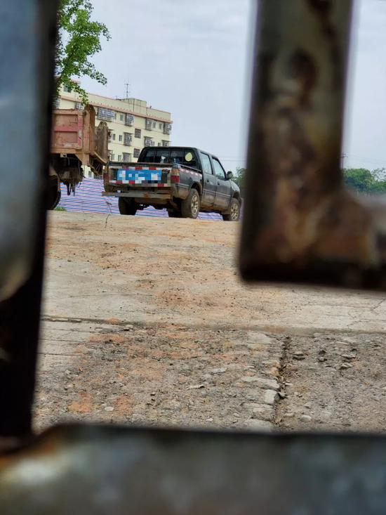 　　6月21日，透过操场大门的缝隙，隐约可以看到门内挖掘现场已被围起了红白蓝帆布。新京报记者 李云蝶 摄