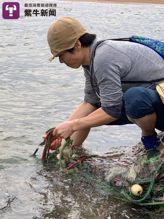 　万云峰在海边拾捡垃圾