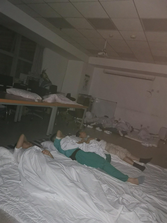 7月20日晚，郑大一附院停电后，方泽民（中）与同事在医院打地铺。受访者供图