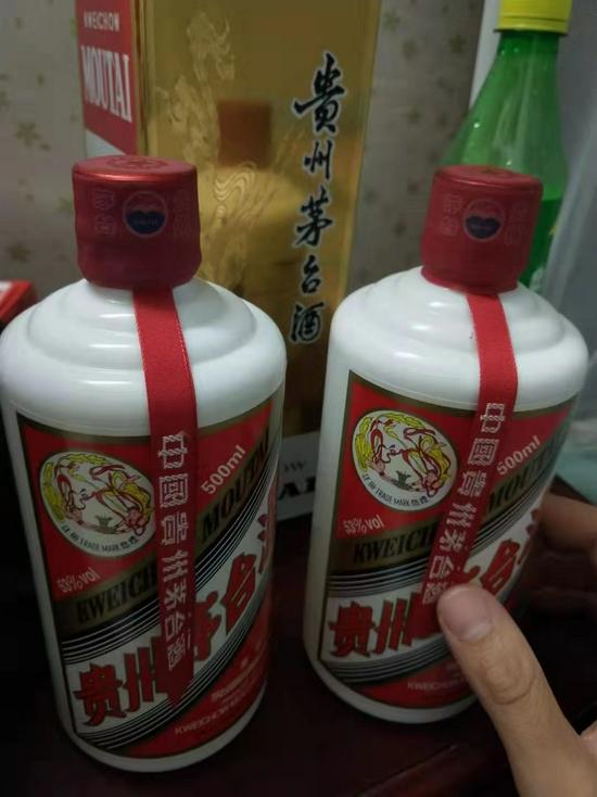 孙阳向记者展示的飞天茅台酒样品照片,其称左为正品,右为高仿品。