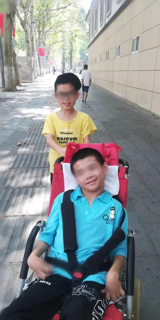 鄢成（轮椅内）与弟弟小伟