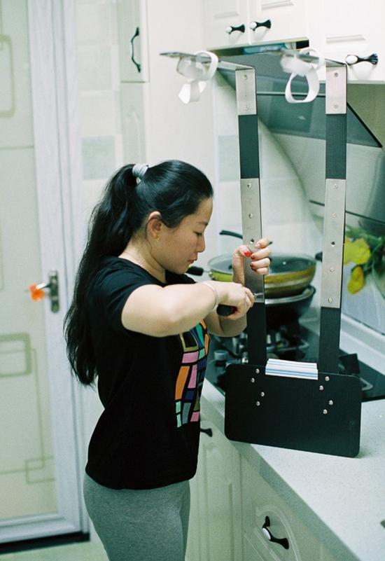　　轮椅上方的松紧带支架，是妈妈根据图纸在淘宝选购材料后亲手制作的支架，能让草根在下棋时更加轻松舒适。