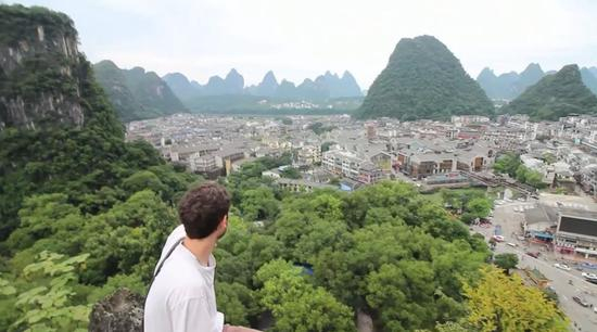 （Kevin和朋友爬上小山坡看风景，视频截图。）