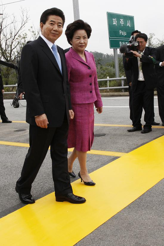 时任韩国总统卢武铉与夫人，徒步走过军事分界线。