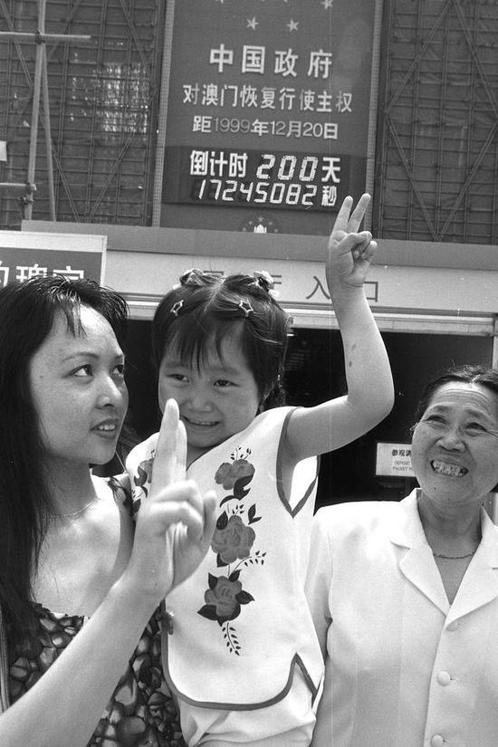　　1999年6月3日是澳门回归倒计时200天，许多北京市民在倒计时牌前合影留念，以庆祝这个有意义的日子。图：张宏江TAKEFOTO
