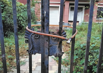 多栋别墅大门紧锁，院内荒草丛生。