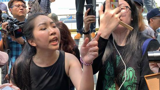 “泼漆女”郭润庭（左）与接机民众发生冲突（图片来源：台湾“中时电子报”）