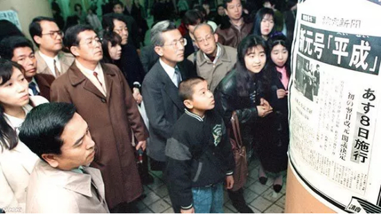 （图为1989年1月日本民众街头围观刊登“新年号”的报纸号外 图源：NHK）