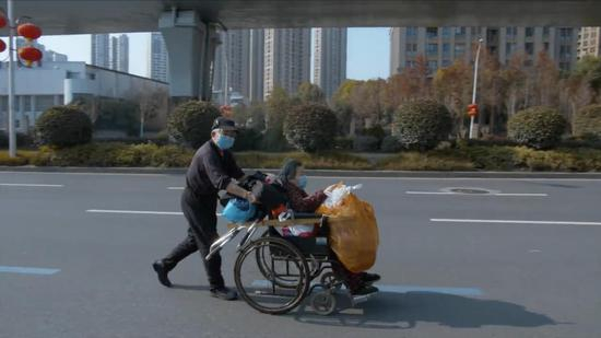 　武汉街头，一位老人用时三小时把家人用轮椅推回家。