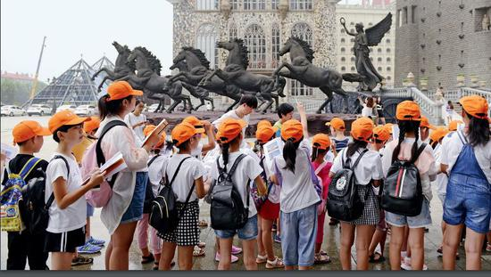 　　8月13日，一所小学组织学生们到美院参观游玩。学生手握画册，观察校园的建筑然后在画册上一一勾选出相对应的景点图。