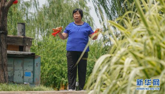 草厂四条居民丁淑凤在北京市东城区三里河练习打快板（6月8日摄）。新华社记者 马晓冬 摄