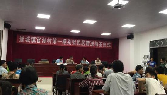 官湖村村民聚集在陈生捐建的新的村委会办公楼，等待摇号