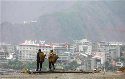 2008年6月22日，北川万名灾民雨中搬家。资料图片/新京报记者 薛珺 摄