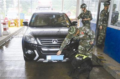 边防官兵正在对出入边境的车辆进行检查。