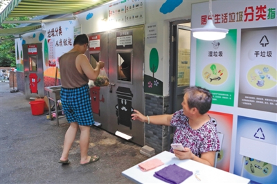 8月7日，上海，志愿者监督居民做好垃圾分类处理。