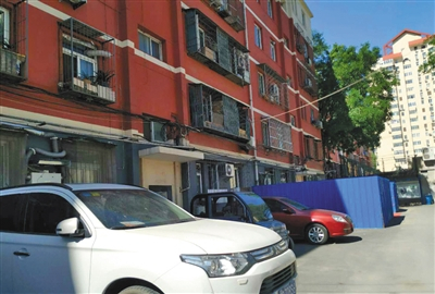 　　其他单元周围已开始施工安装电梯（蓝色围挡处），但涉事单元仍没有动静，部分业主心里十分着急。受访者供图
