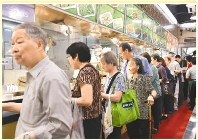 　　为了缓解老人因儿女白天上班，中午吃饭难的问题，2016年广东省广州市开始推广老人饭堂，如今已全面覆盖街道和村居。图为老人们在广州天河区石牌街道的指定助餐点排队取餐。 　　新华社记者 梁 旭摄
