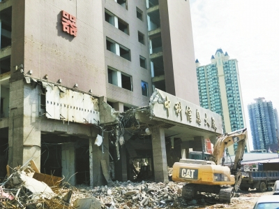施工人员正在用钩机拆除中科大厦的裙楼