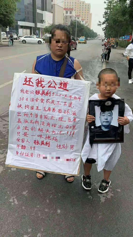 母子街头举牌。网络截图