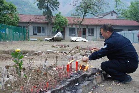 ▷李林国在地震遗址前祭祀儿子