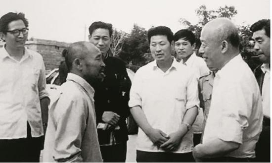林乎加（前右）在调研期间与当地农民交流。