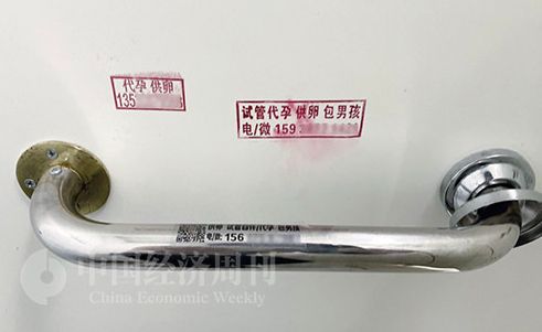  医院厕所的门板上，也被各种代孕机构打上了非法广告