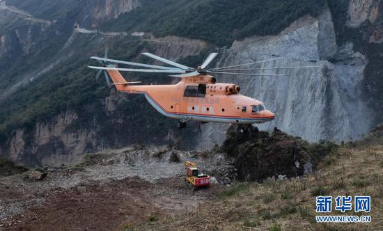 　　米-26重型直升机吊运一台挖掘机抵达四川省布拖县阿布洛哈村上空准备降落（2019年12月5日摄）。为了打通四川省布拖县阿布洛哈通村公路，施工单位租用的一架米-26重型直升机克服高山峡谷、天气多变等不利因素，从布拖县城吊运大型施工设备到阿布洛哈村，为两边分头掘进施工提供大型机械保障。新华社记者 江宏景 摄