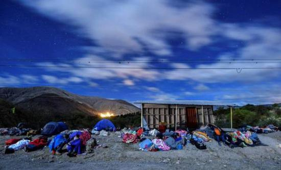 　　当地时间2018年8月22日，厄瓜多尔伊瓦拉，委内瑞拉难民踏上移民路，徒步前往秘鲁。图为在路边露天睡觉的难民。视觉中国 图