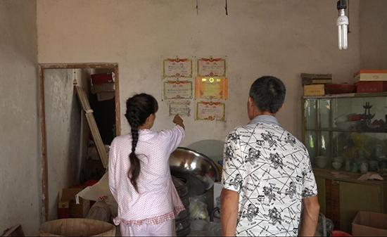 老房子墙上贴有杨轩读书时的奖状，杨崇生夫妇舍不得撕掉。